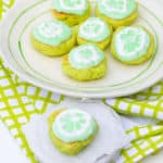 six key lime cookies on a plate and one key lime cookie on a smaller plate in front of larger plate of cookies