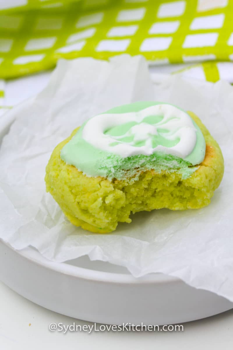 key lime cookie with frosting shaped like a slice of lime on a plate with a bite taken out of it