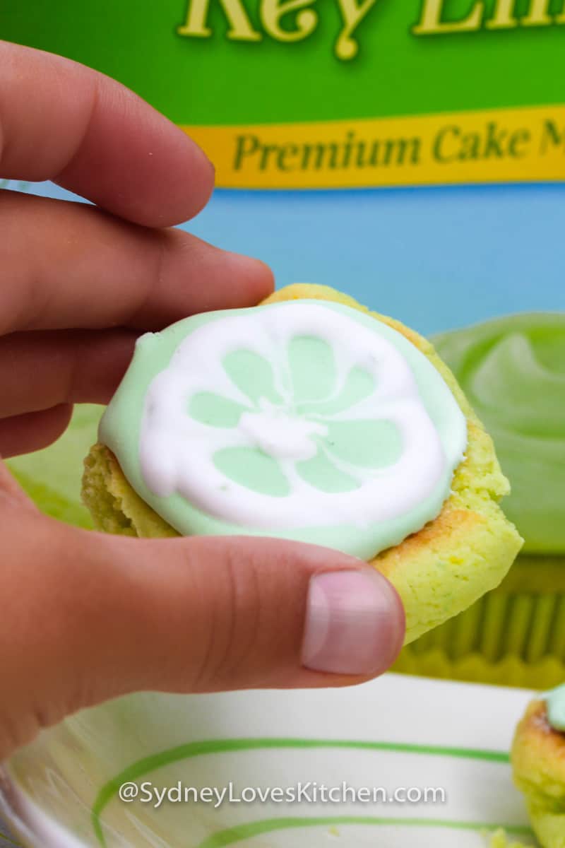 hand holding key lime cookie in front of Pillsbury key lime cake mix box
