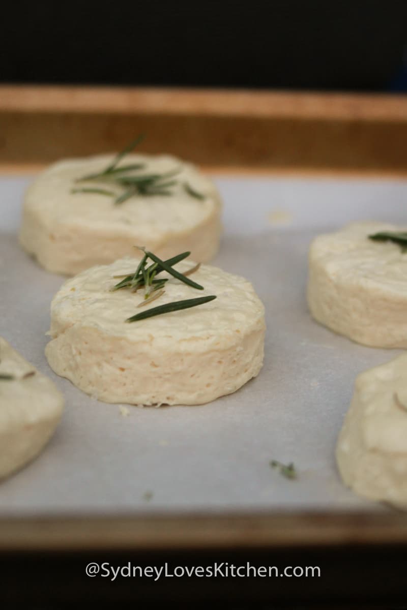 Uncooked rosemary biscuits on a cookie sheet