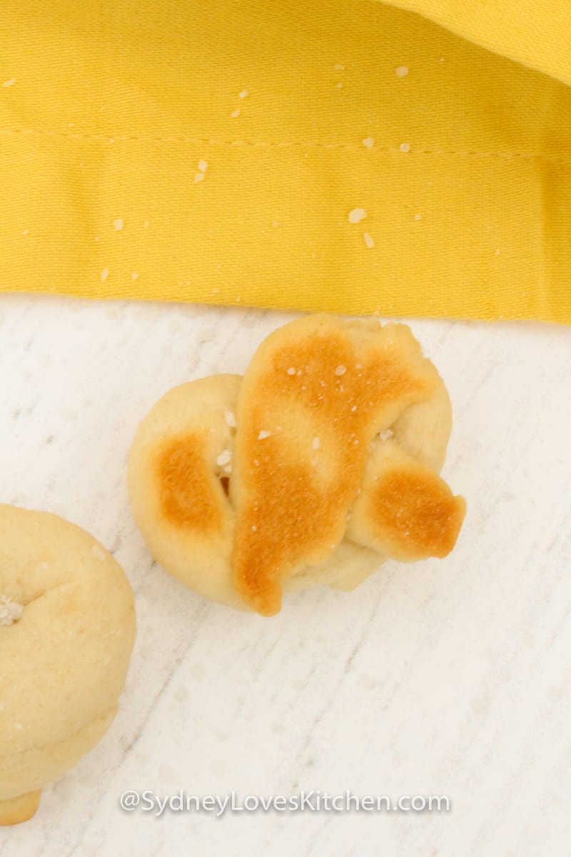 baked pretzel with yellow napkin in background.