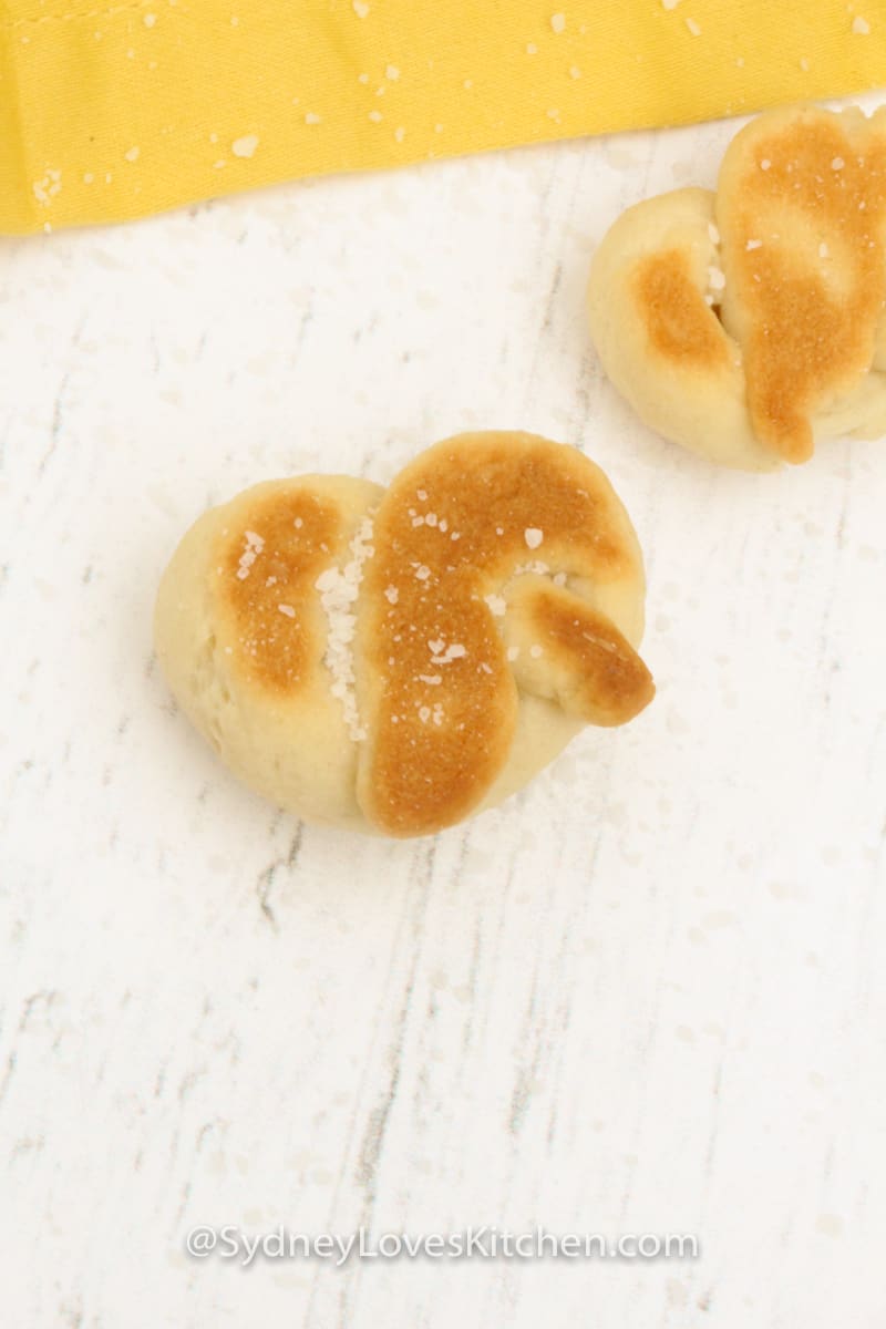 two pretzels cooked and placed on a white board 