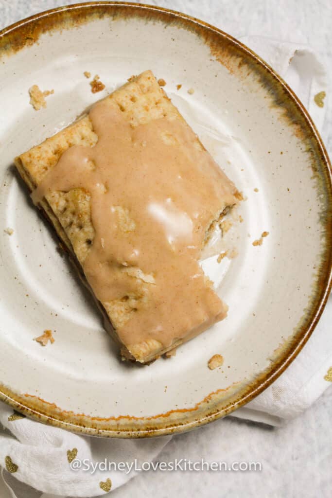 overhead view of cinnamon pop tart on a plate with bite taken out of it